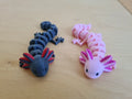 Axolotl articulado flexible impreso en 3D azul marino con branquias rojas y rosa con branquias fucsia