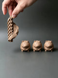 Capibara articulada flexible impresa en 3D con acabado efecto madera en fila de tres figuras