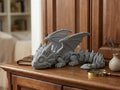 Dragón mini articulado flexible impreso en 3D gris con alas desplegadas sobre mueble de madera