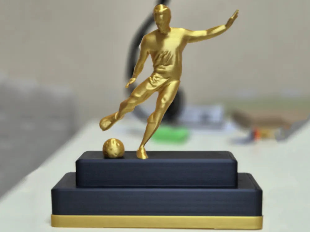 Trofeo jugador de fútbol dorado personalizable impreso en 3D sobre base negra escalonada