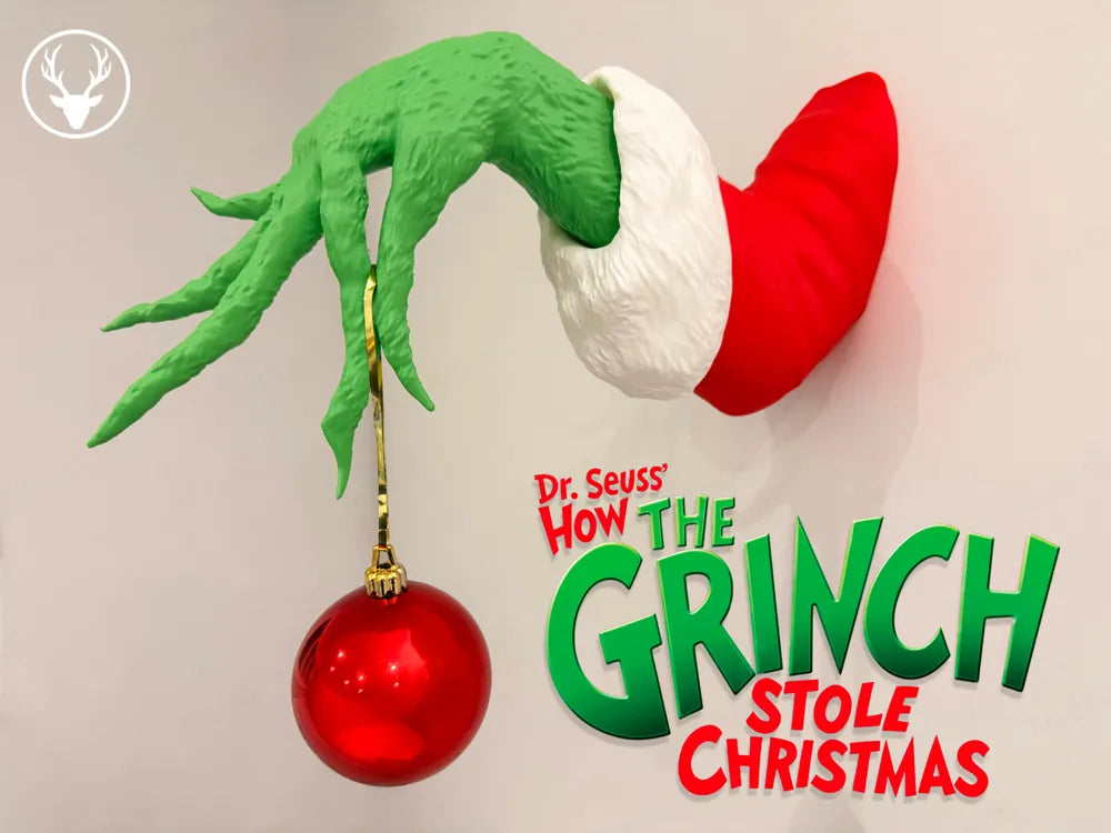Mano del Grinch adorno de pared 3D 30cm en colores verde, blanco y rojo sosteniendo una bola navideña roja
