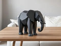 Escultura decorativa 3D de elefante poligonal en color negro sobre mesa de madera