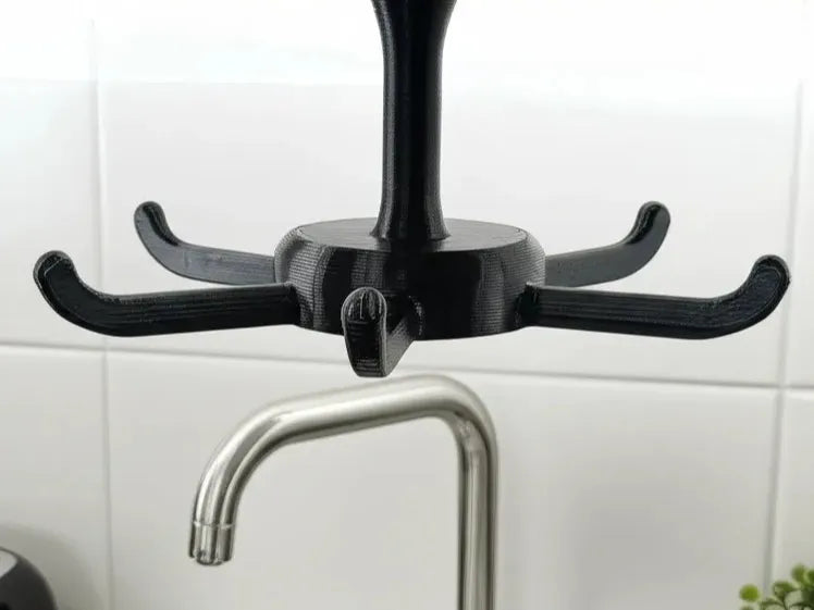 Gancho giratorio 3D negro con 4 brazos enganchado al grifo de cocina