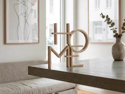 Letras decorativas HOME impresas en 3D en PLA color natural sobre mesa de comedor en ambiente minimalista escandinavo