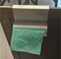 Porta bolsas 3D impreso colgado en puerta de mueble de cocina con bolsa verde