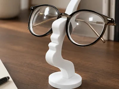 Soporte para anteojos 3D con forma de nariz y bigote color blanco sobre escritorio de madera
